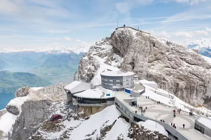 Snow-covered summit of Mount Pilatus with a modern observation deck offering breathtaking views of the Swiss Alps.