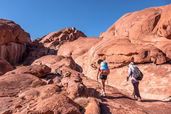 Hikers trek Sinai desert rocks on Mount Sinai climb tour from Sharm El Sheikh to St Catherine Monastery