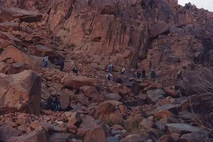 Hikers ascending rocky Mount Sinai path at dawn, guided climb from Sharm El Sheikh to St Catherine Monastery