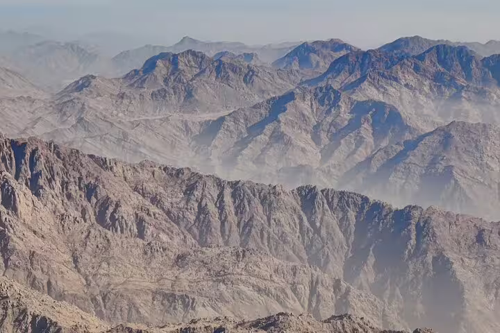 Hazy mountain ranges in Sinai Desert seen on Mount Sinai Moses Mountain trek, St Catherine Monastery day tour