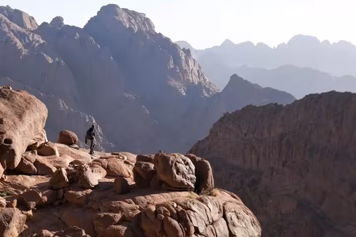 Hiker on rocky ridge near Mount Sinai summit, Sinai Mountains view on Sharm El Sheikh day tour