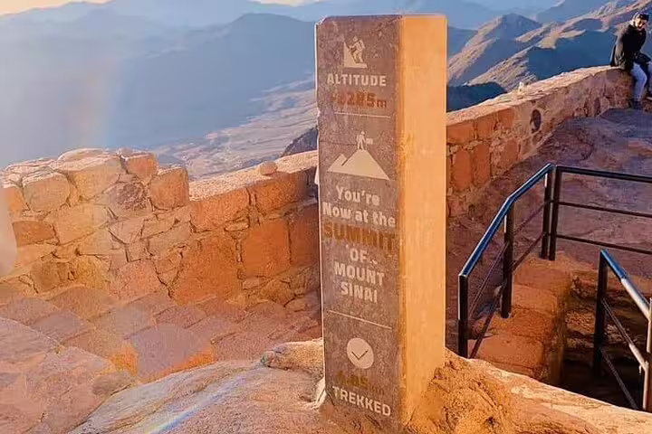 Summit marker at Mount Sinai with panoramic Sinai mountains, sunrise hike from Sharm El Sheikh to St Catherine