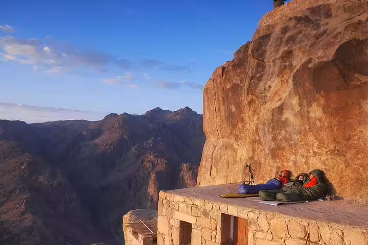 Hikers resting on Mount Sinai summit terrace at sunrise, Mount Sinai climb from Sharm El Sheikh overnight tour