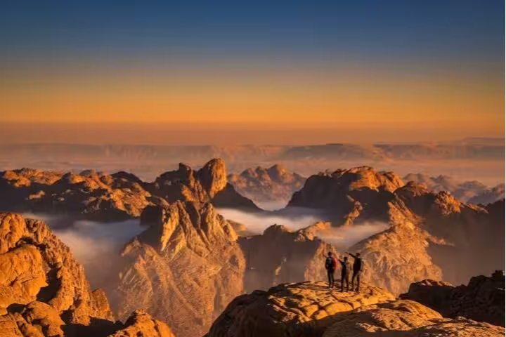 Hikers at Mount Sinai summit at dawn, panoramic Sinai peaks on Mount Sinai and St Catherine Monastery tour