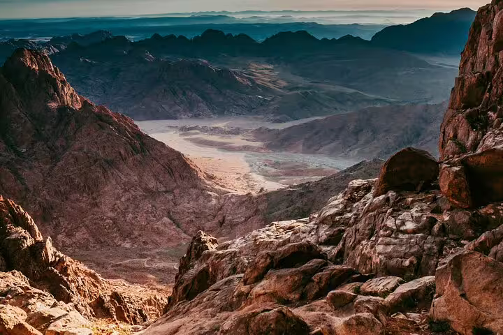 Sunrise panorama over Mount Sinai desert valleys, view from summit on private overnight trip from Cairo