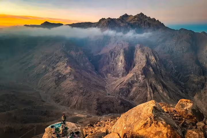 Sunrise view from Mount Sinai summit on Sharm El Sheikh tour, rugged Sinai mountains above cloud layer