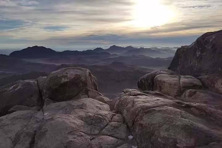 Sunrise view from Mount Sinai summit on private Sharm tour, rocky peak and Sinai mountains panorama