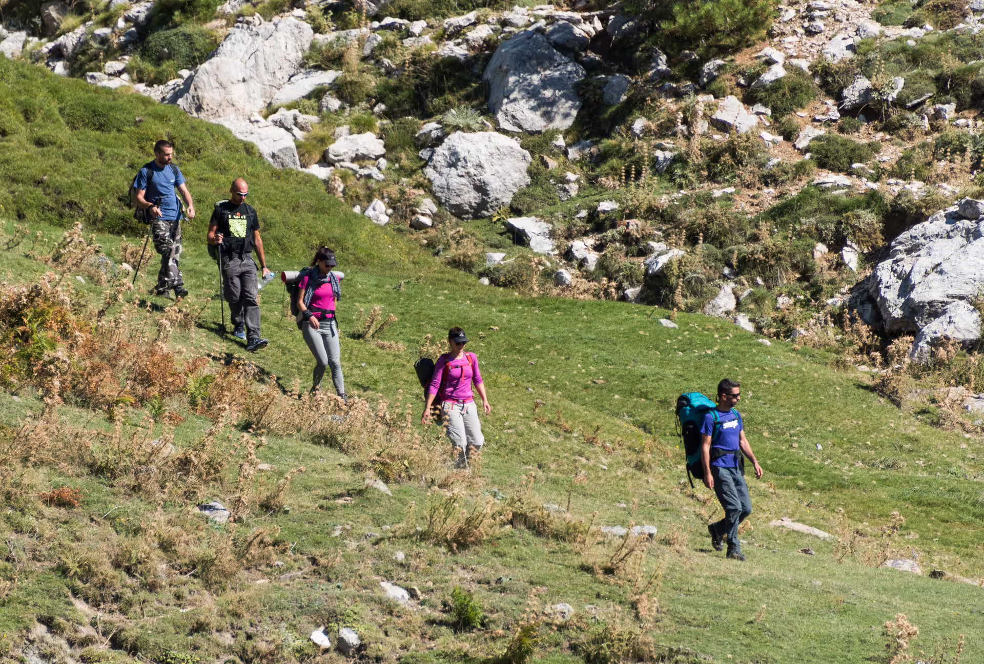 Guided hikers crossing a grassy slope on Mount Taygetos trail, preparing for the 2407m summit trek in Greece