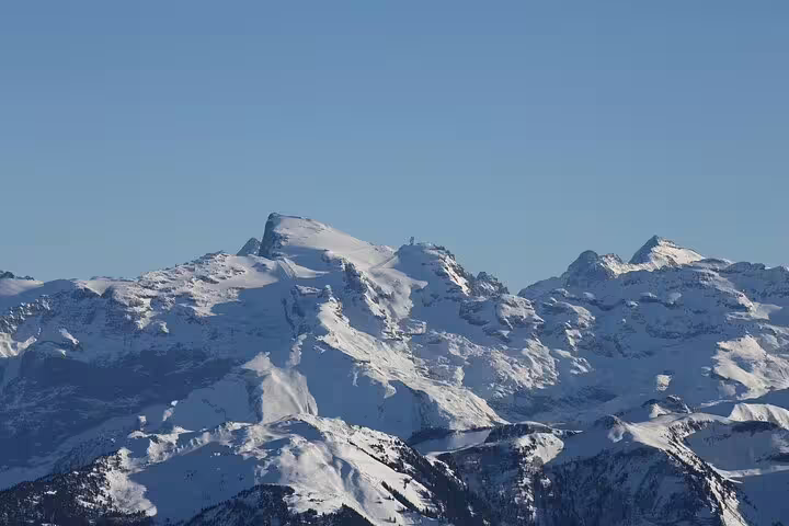 Snow-covered Mount Titlis peaks under clear blue sky, Swiss Alps panoramic view