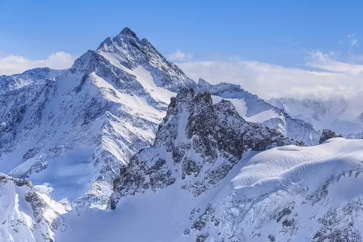 Majestic snow-covered peaks of Mount Titlis under a clear blue sky, ideal for scenic private day trips.