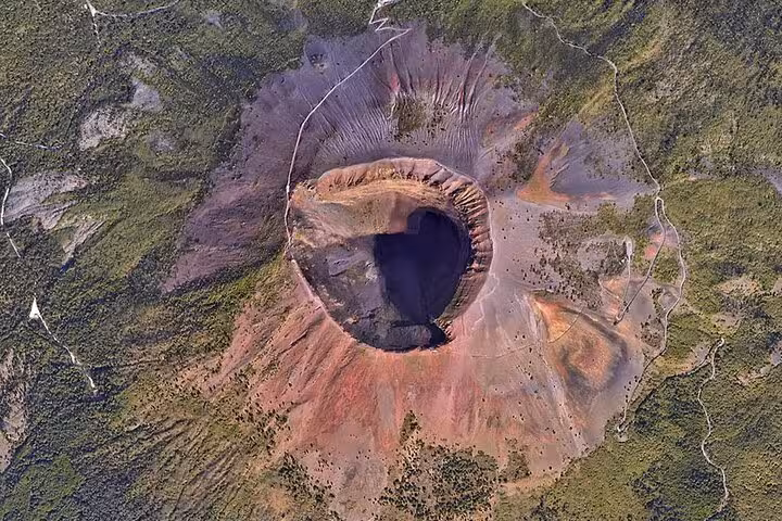 Aerial view of Mount Vesuvius' crater showcasing its dramatic geological features and lush surrounding landscapes.