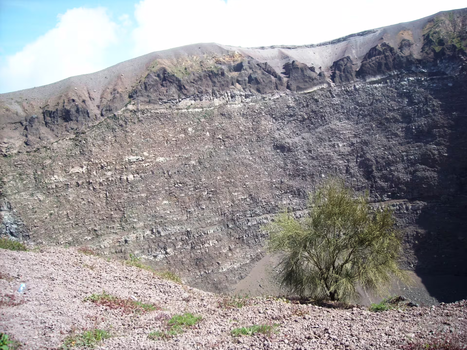 Panoramic view into Mount Vesuvius crater with rocky rim and sparse vegetation on a full-day tour including local wine tasting