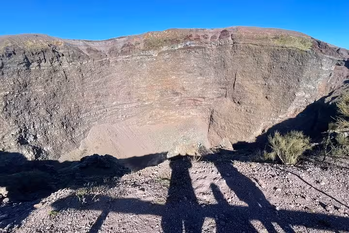 Stunning view of Mount Vesuvius crater under clear blue skies, a highlight of the Pompeii and wine tasting tour.