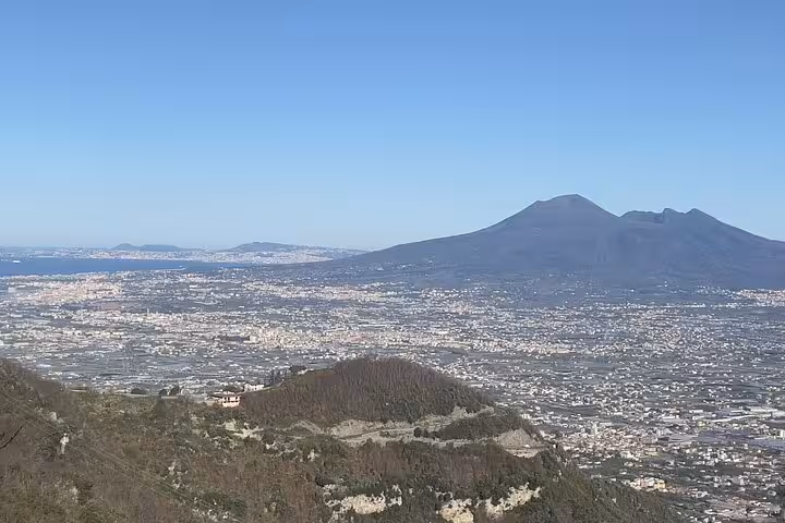 A breathtaking view of Mount Vesuvius overlooking the sprawling cityscape of Naples on a clear day.