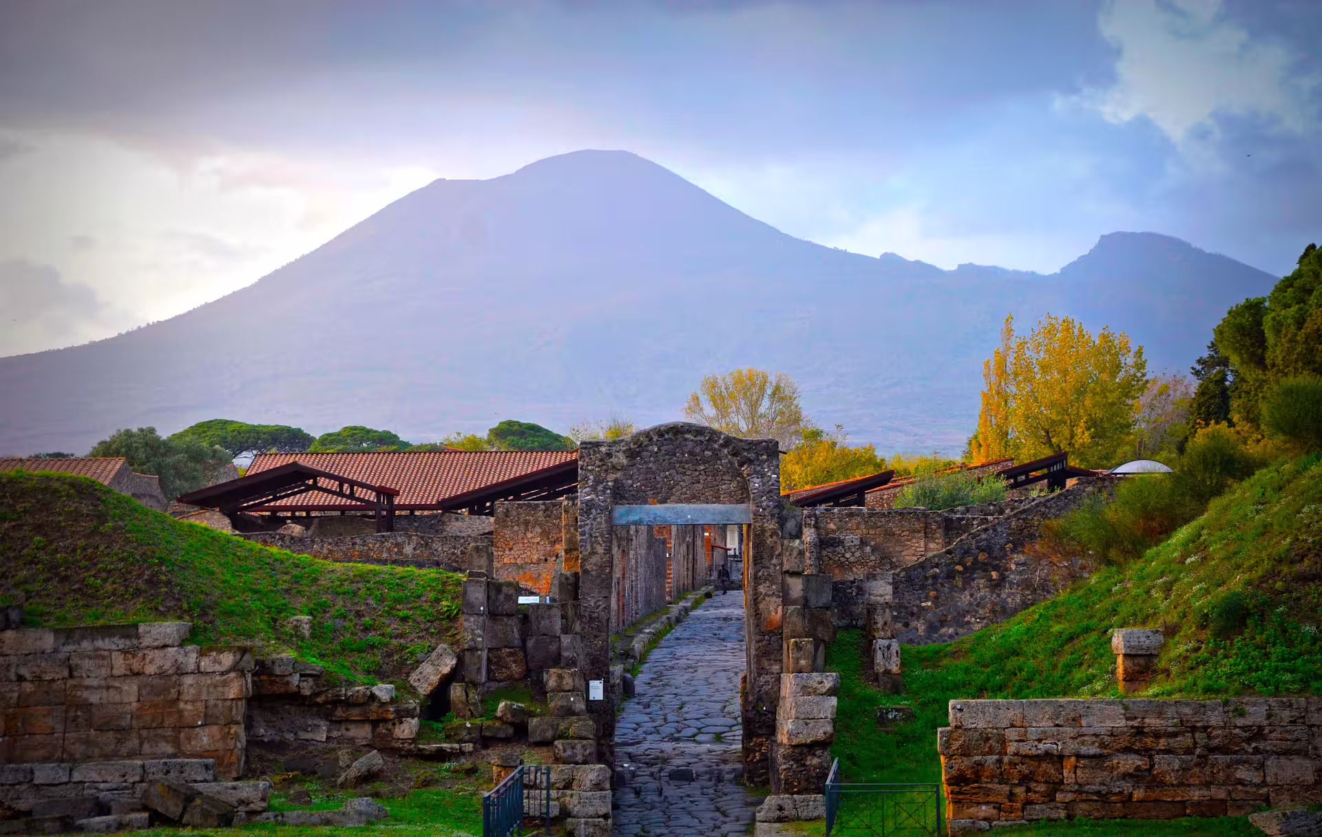 Sunset over Mount Vesuvius and Pompeii city gate ruins on a small group Herculaneum and winery tour from Naples