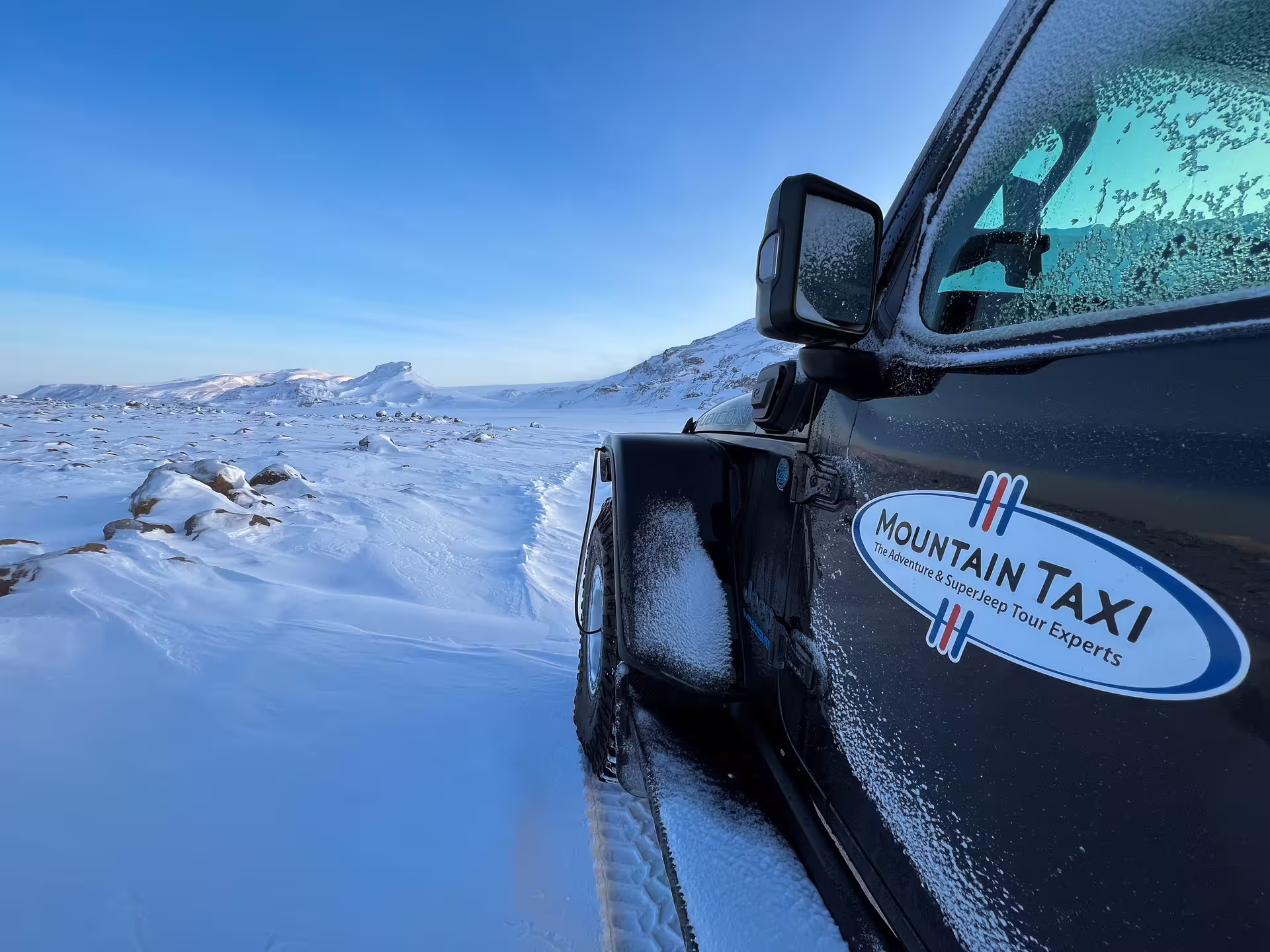 Mountain Taxi super jeep on snowy highland terrain during a full-day private glacier tour in Iceland