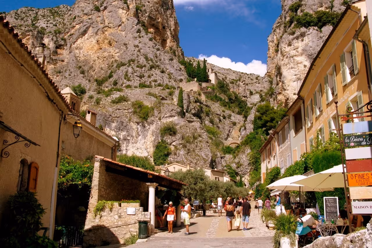 Charming village street in Moustiers-Sainte-Marie with limestone cliffs and Provençal shops in Verdon canyon