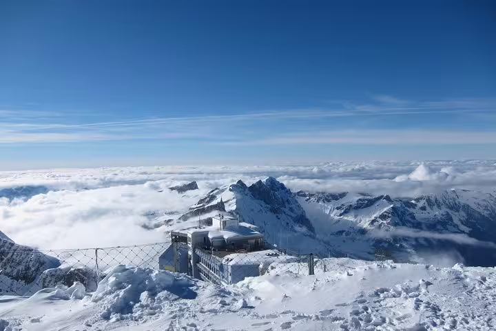 Majestic snowy peaks and observatory at Mt. Titlis offering breathtaking alpine views on Lucerne small group tour.