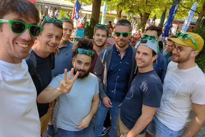 Group of men wearing green sunglasses smiling outdoors in Munich during a brewery tour activity