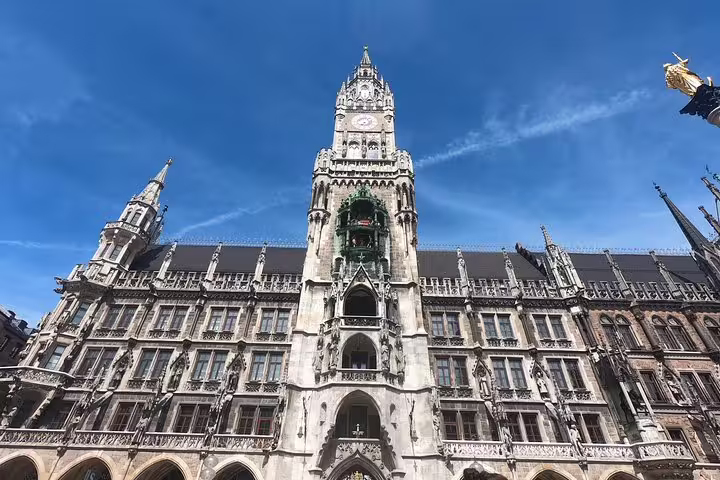 Gothic facade of Munich New Town Hall with ornate clock tower under blue sky