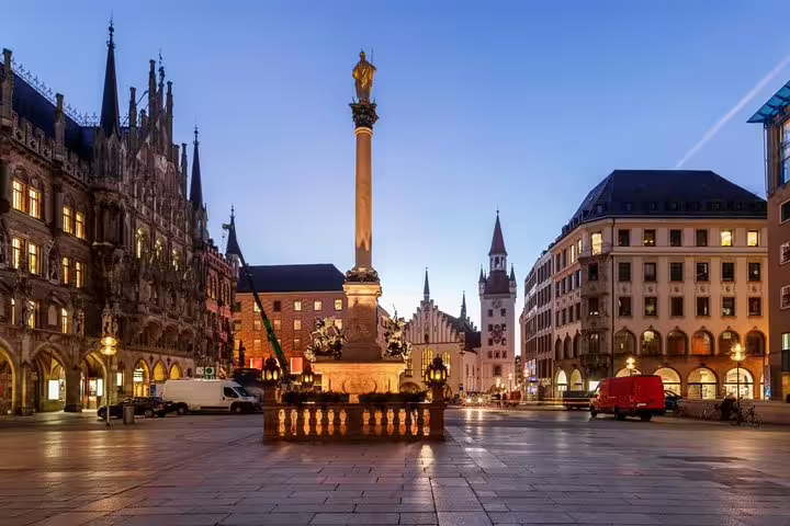 Marienplatz square at dusk with Mariensäule column and illuminated New Town Hall in Munich