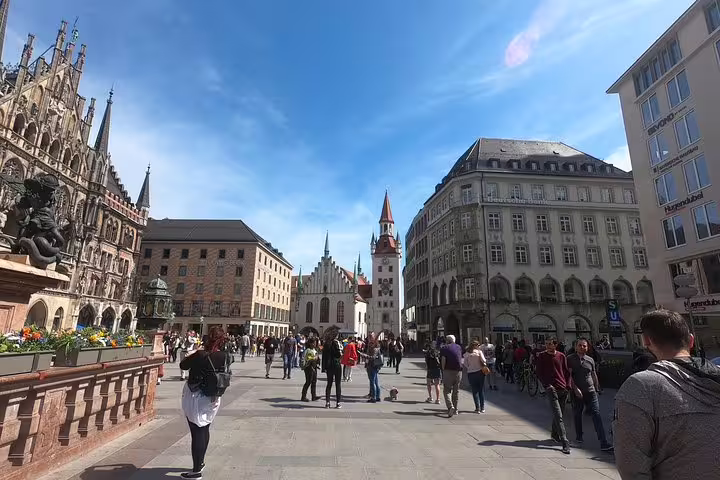 Marienplatz square in Munich with historic town hall and crowds of tourists on a sunny day