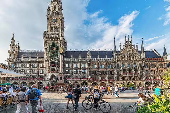 Tourists exploring Marienplatz square with Munich's iconic Gothic New Town Hall in the background
