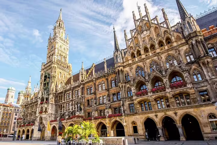 Gothic facade of Munich's New Town Hall at Marienplatz with ornate spires and red flower decorations