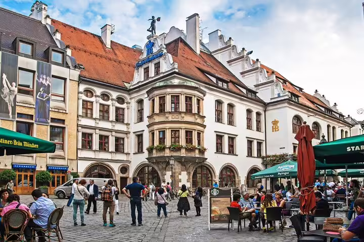 Historic Hofbräuhaus building and cobblestone square in Munich Old Town with outdoor café seating