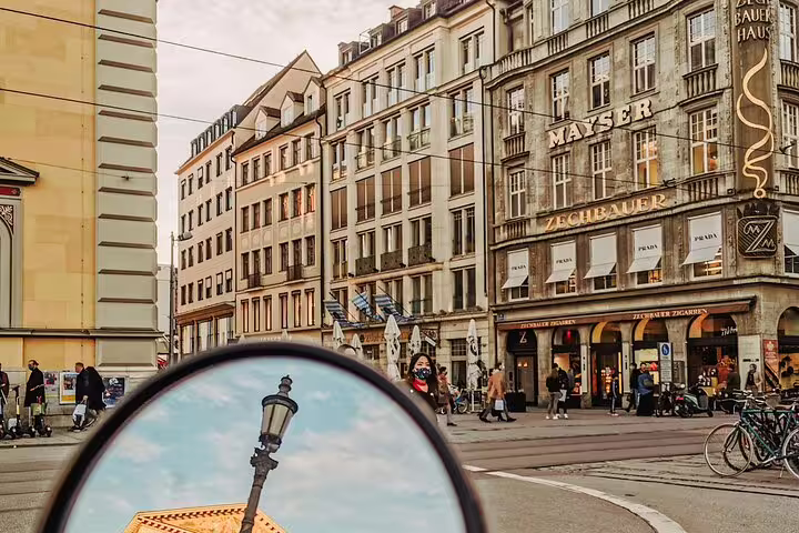 Spy game mirror reflection in Munich Old Town square with historic Zechbauer and Mayser buildings