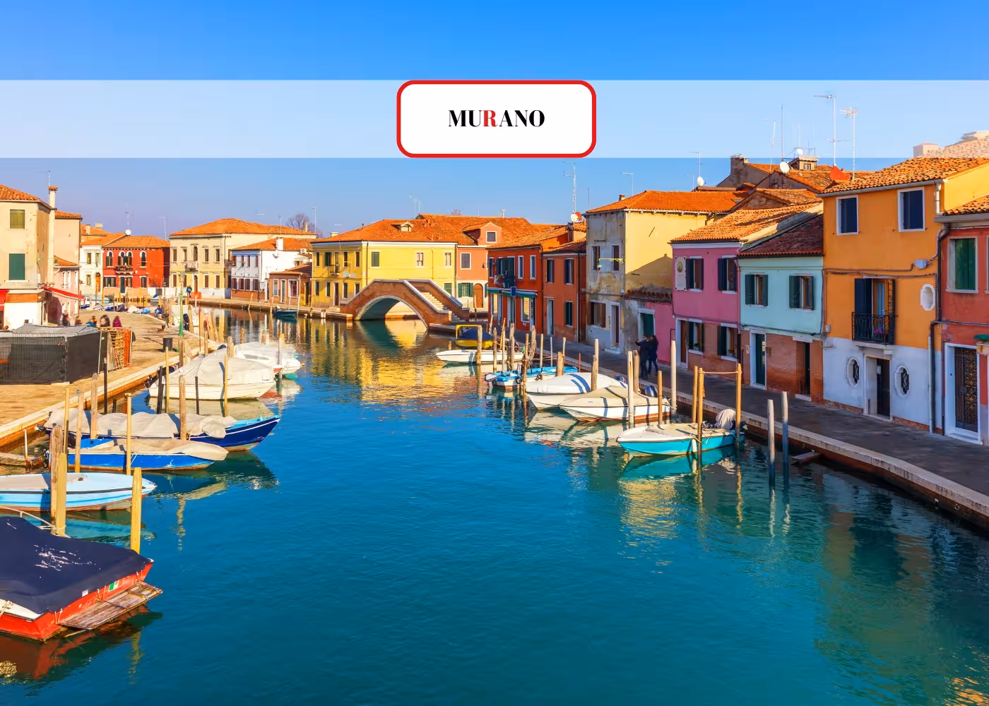 Scenic view of colorful buildings and boats along a canal in Murano, part of a Venice Islands guided cruise.