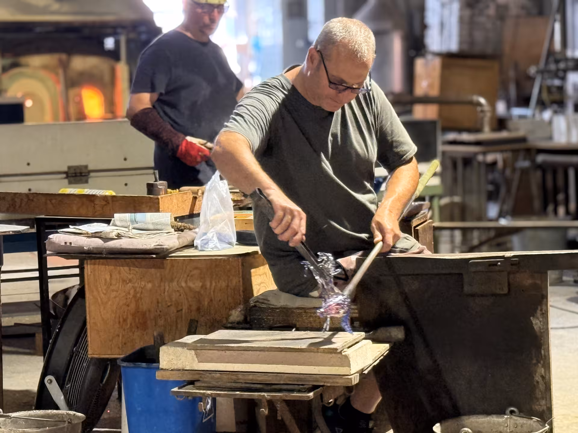 Artisan crafting Murano glass in a traditional workshop, highlighting the intricate process of glassblowing.