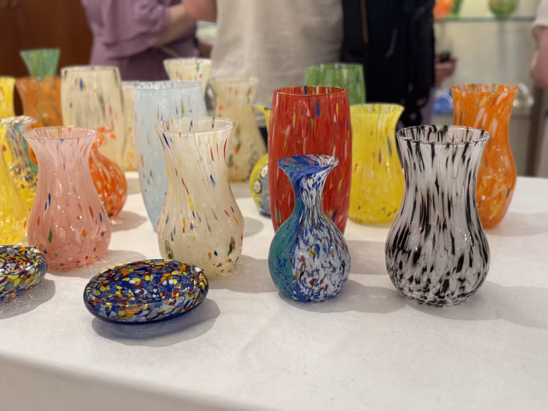 Colorful Murano glass vases and bowls on display during private tour of the island's renowned glass workshops.