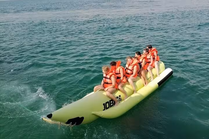Guests ride a banana boat on Musandam sea during dhow cruise tour with snorkeling, fishing and lunch