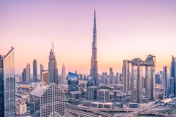 Dubai skyline at sunset with Burj Khalifa, showcasing the cityscape guests enjoy on Muscat to Dubai private transfer