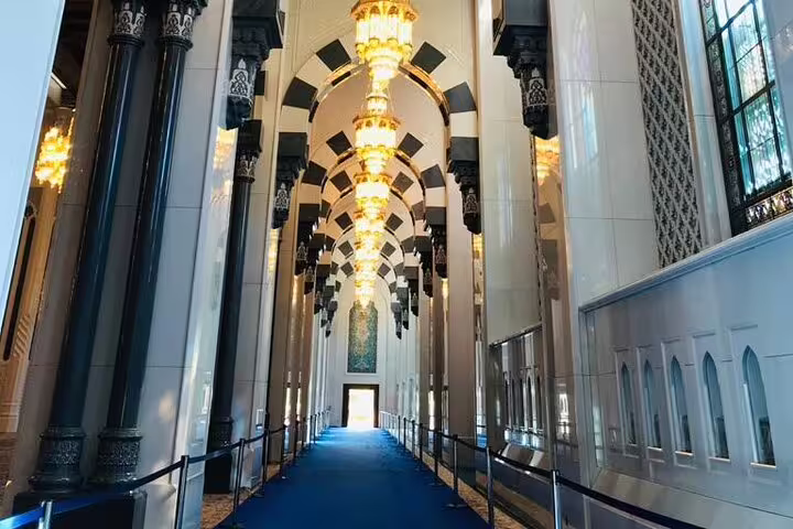 Walk through the majestic halls of Muscat's Grand Mosque, showcasing elegant arches and luxurious chandeliers on your tour.