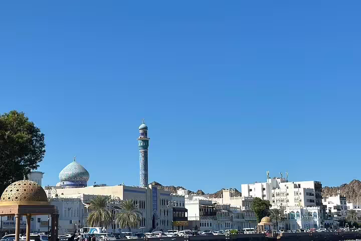 Discover Muscat's vibrant skyline featuring a mosque and traditional architecture on a guided private morning tour.