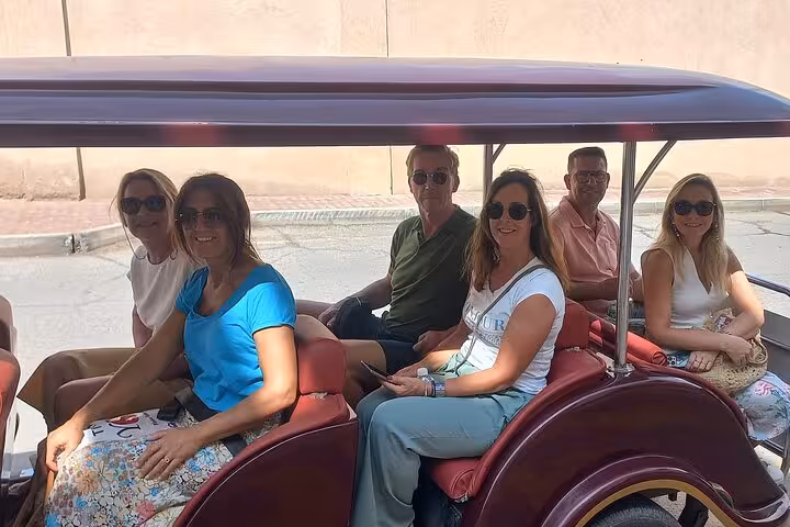 Happy group of tourists enjoying a private transfer sightseeing ride during Muscat to Nizwa tour in Oman