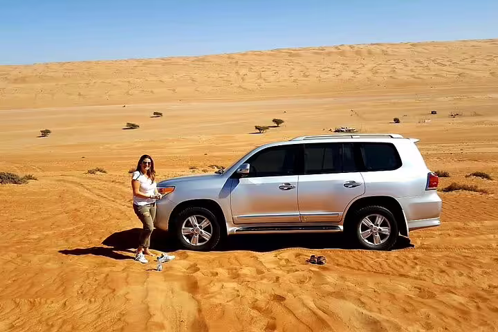 4x4 vehicle in sandy desert landscape, ideal for adventurous journey from Muscat to Wadi Shab.
