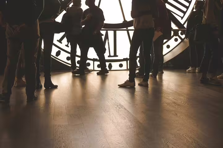 Visitors silhouetted against the giant clock face inside Musée d'Orsay museum