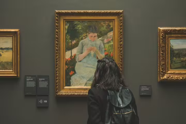 Visitor viewing Impressionist painting at Musée d'Orsay guided tour