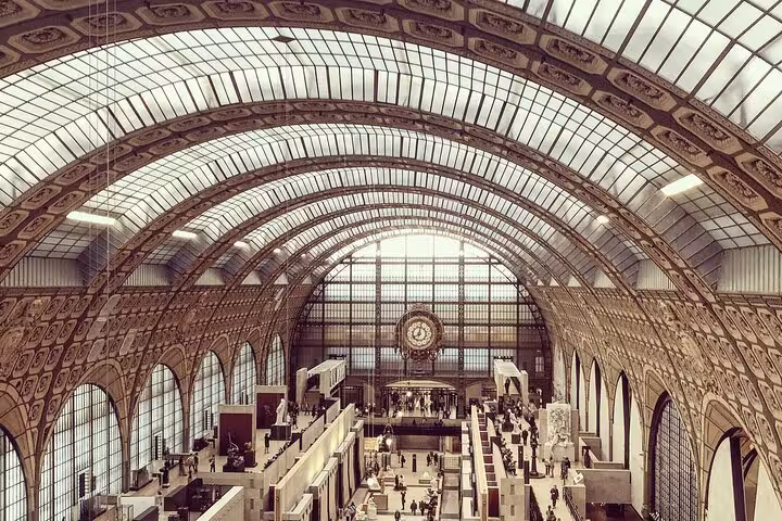 Grand vaulted glass ceiling and ornate clock inside Musée d'Orsay Paris museum hall