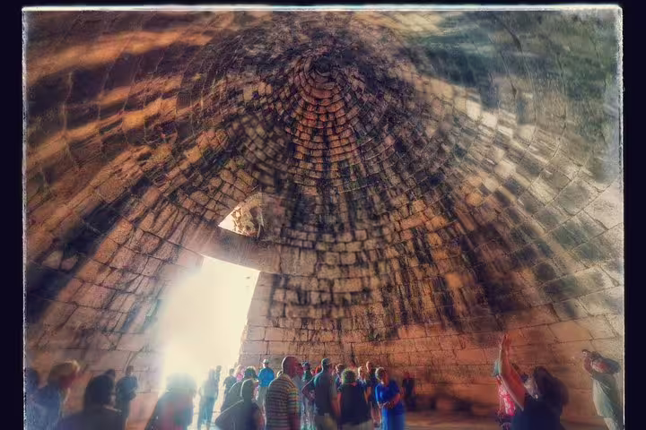 Visitors inside the Mycenae tholos tomb on a small-group day tour from Athens to Epidaurus and Nafplio