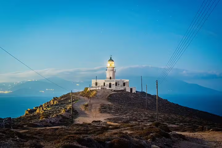 Mykonos lighthouse on a rocky headland at sunset, panoramic Aegean sea views on island sightseeing tour