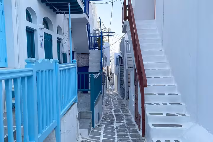 Charming Mykonos Old Town alley with white steps and blue doors, featured on a private highlights tour