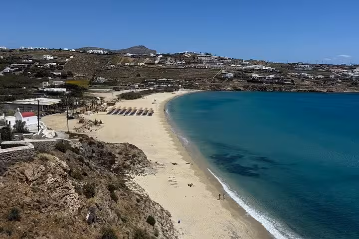 Panoramic view of Ornos Beach, Mykonos, with turquoise water and sunbeds on a private island tour