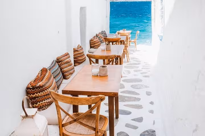 Seaside cafe alley in Mykonos Chora with turquoise Aegean views on a small group island walking tour