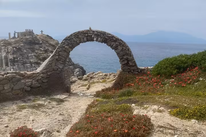 Stone arch ruins on a rocky Mykonos coastline with sea views, highlight of a half-day private island tour
