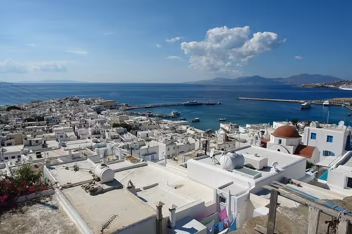 Panoramic view of Mykonos Town and harbor with Cycladic rooftops and blue sea on island highlights tour