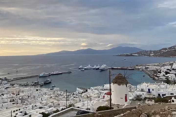 Mykonos Town harbor view with whitewashed houses, windmill and yachts on a private highlights tour